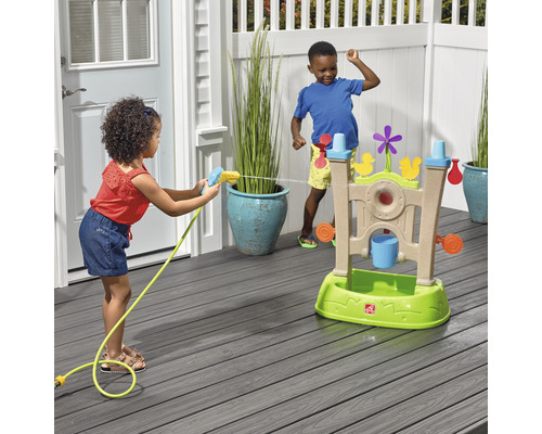 Deux enfants jouent avec une table d''eau à l''extérieur et utilisent un pistolet à eau.