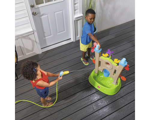 Deux enfants jouent avec une table de jeu d''eau sur une terrasse.