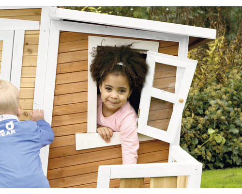 Enfant à la fenêtre d''une cabane en bois