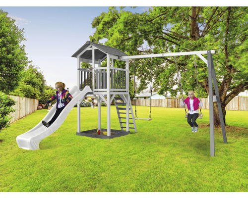 Aire de jeux avec tour, toboggan et balançoire dans le jardin