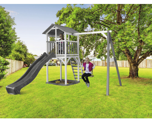 Aire de jeux avec balançoire, toboggan, bac à sable et tour de jeux dans le jardin