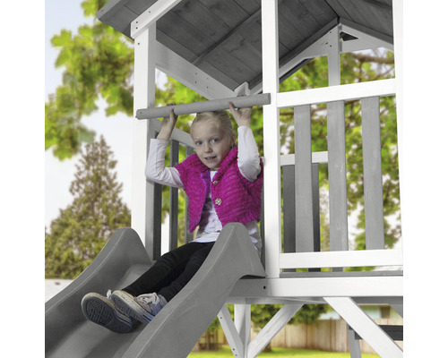 Fille sur une tour de jeu avec toboggan et barre d''escalade