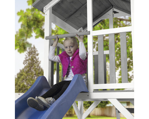 Fille sur un toboggan d''une tour de jeux dans le jardin.