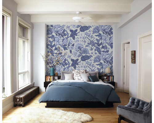 Schlafzimmer mit gemusterten Tapeten, Bett und Heizkörper