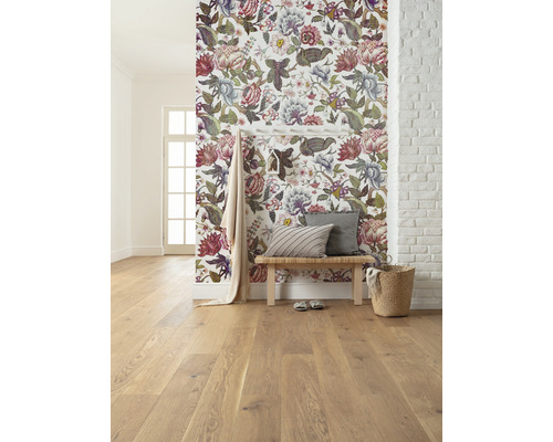 Pièce lumineuse avec papier peint floral, plancher en bois, banc et décorations.