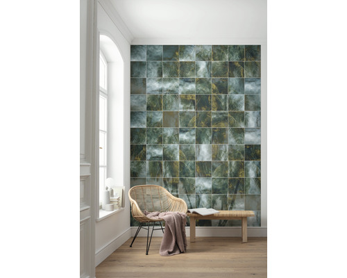 Décoration murale avec des carreaux carrés, un fauteuil en rotin et un banc en bois dans une pièce