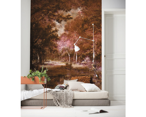 Une chambre avec un papier peint photo représentant un paysage forestier, un lit avec des coussins et un couvre-lit, et un lampadaire.
