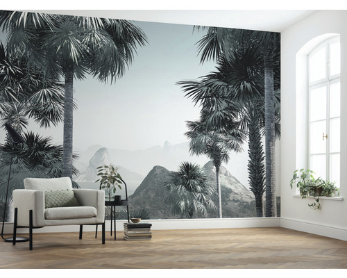 Salon avec papier peint photo avec motif de palmier et fauteuil