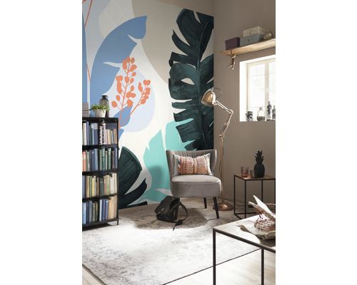 Dekoratives Zimmer mit Fototapete mit Pflanzenmotiven, Sessel, Bücherregal und Stehlampe