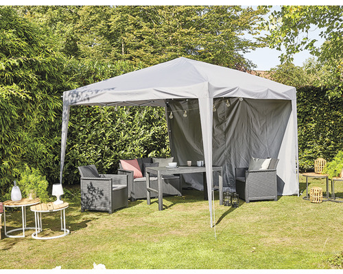 Tonnelle grise avec mobilier de jardin sur une pelouse