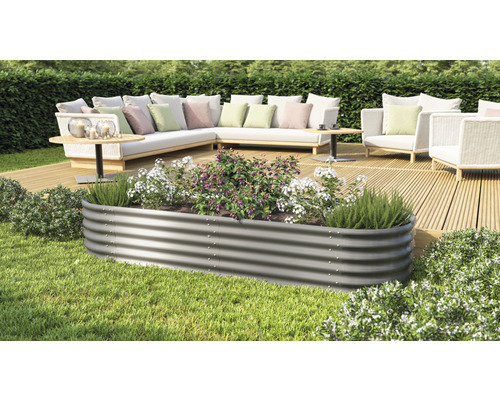 Jardinière surélevée en métal avec plantes sur une terrasse avec mobilier de jardin