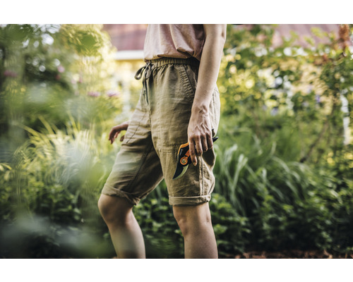 Frau im Garten mit einer Gartenschere.