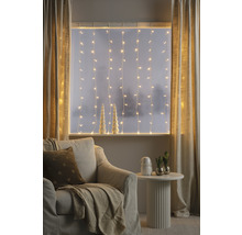 Salon confortable avec guirlandes lumineuses, rideaux, fauteuil et table d''appoint pour une ambiance chaleureuse.