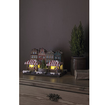 Weihnachtsmarktdorf mit Beleuchtung und dekorativen Häusern auf einem Tisch