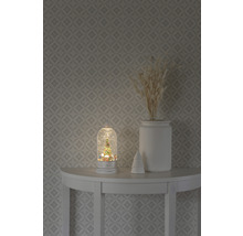 Boule à neige décorative avec motif de sapin de Noël sur une table