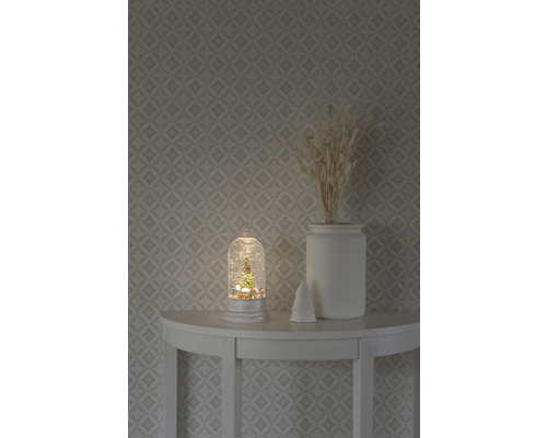 Boule à neige décorative avec motif de sapin de Noël sur une table