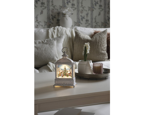 Lanterne décorative avec motif de Noël sur une table, entourée d''accessoires d''intérieur pour une ambiance festive