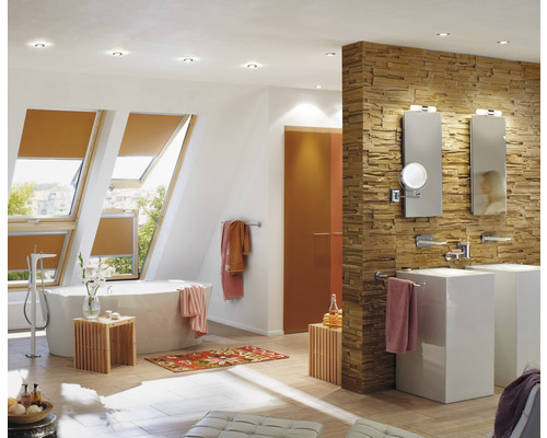 Salle de bain lumineuse avec fenêtres de toit, baignoire et double vasque