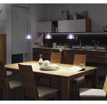 Esszimmer mit Holztisch, Stühlen und drei Pendelleuchten über dem Tisch.