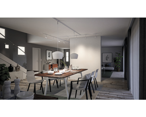 Salle à manger lumineuse avec table en bois, chaises et éclairage sur rail