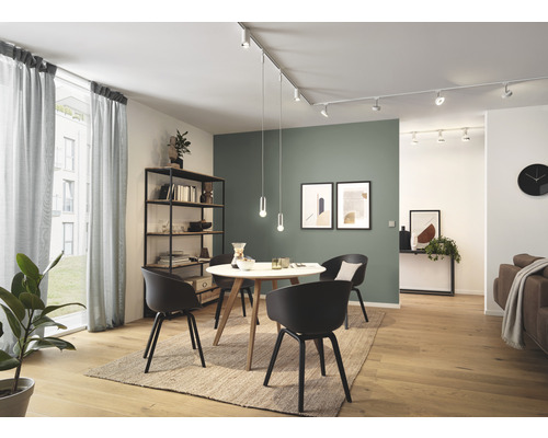 Salon lumineux avec table à manger, chaises, étagères et système de rails linéaires avec spots et suspensions