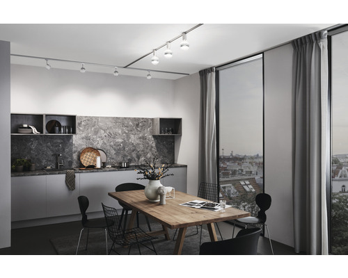 Helles Esszimmer mit Küchenzeile, Esstisch und Schienensystem mit Strahlern