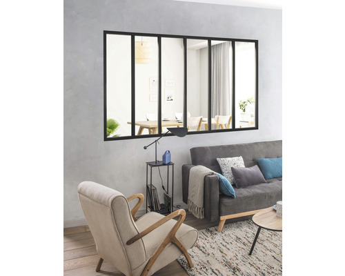 Salon avec miroir de style industriel, canapé et fauteuil