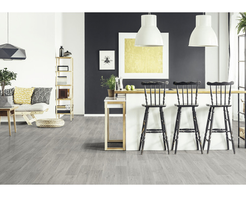 Pièce lumineuse avec sol gris aspect bois, tabourets de bar et étagères.