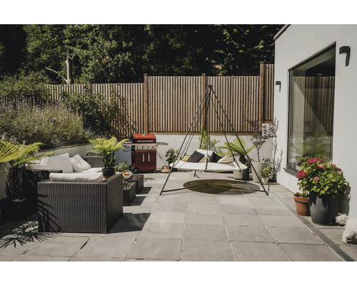 Helle Gartenterrasse mit Sitzgruppe, Hängeliege, Grill und Holzzaun