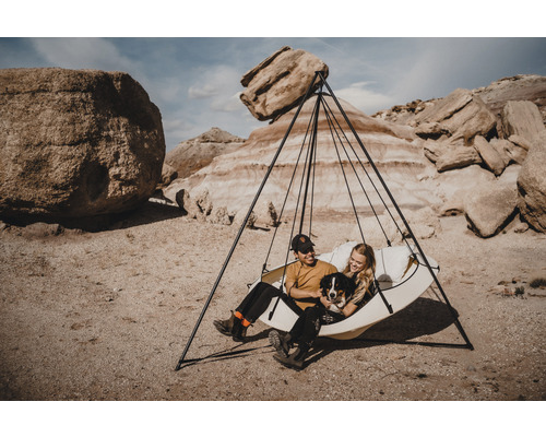 Personen mit Hund in einer Hängematte mit Gestell in einer Felslandschaft