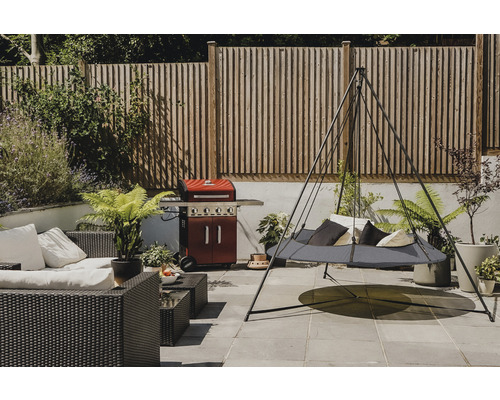 Gartenszene mit Hängematte, Lounge-Möbeln und Grill