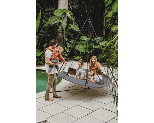 Eine Familie entspannt in einer Hängehöhle im Garten.