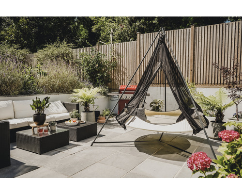 Gartenszene mit Hängematte, Sitzgruppe und Pflanzen auf einer Terrasse.