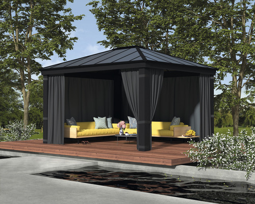 Scène de jardin avec pavillon sur une terrasse en bois, équipée de canapés et de rideaux