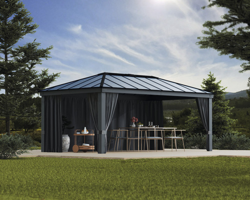 Pavillon de jardin avec rideaux, table et chaises à l''extérieur