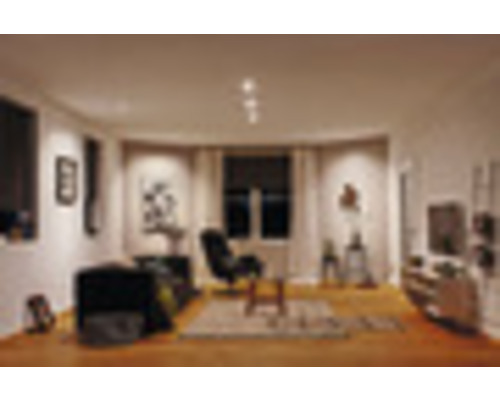 Wohnzimmer mit Sofa, Sessel, Teppich und Dekorationsartikeln