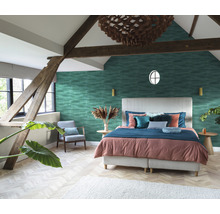 Helles Schlafzimmer mit Doppelbett, gemusterter Tapete und Holzbalken