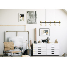 Atelier d'artiste avec peintures, toiles, chaise et commode à tiroirs