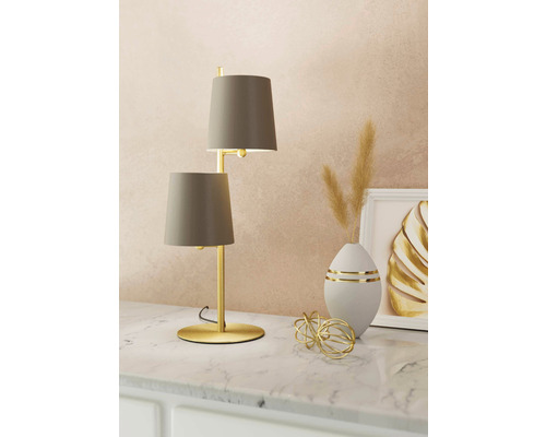 Tischleuchte mit zwei Schirmen und goldenem Gestell auf einer Kommode