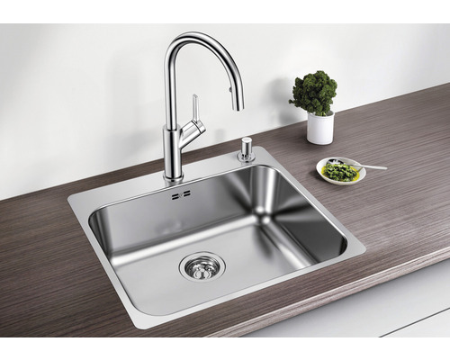 Évier en acier inoxydable avec robinet et distributeur de savon sur un plan de travail