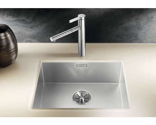 Évier en acier inoxydable avec robinet sur un plan de travail