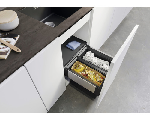 Système de tri des déchets dans une cuisine moderne avec des placards blancs