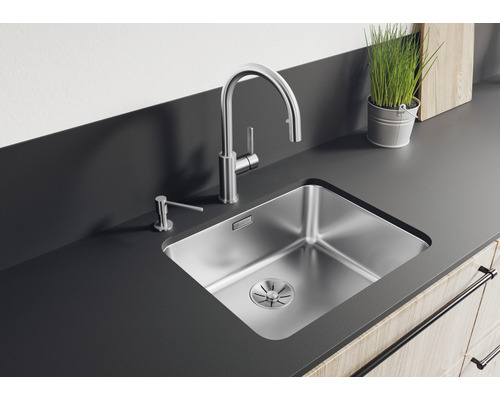 Évier en acier inoxydable avec robinet et distributeur de savon sur un comptoir de cuisine