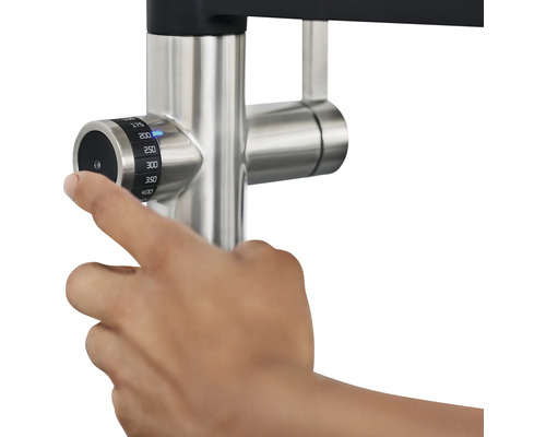 Une main règle la température du robinet