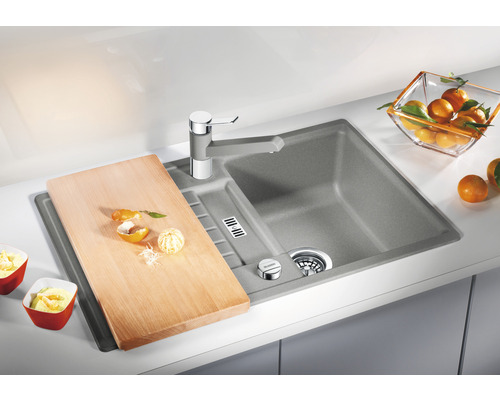 Küchenspüle mit Schneidebrett und Armatur auf einer Küchentheke.