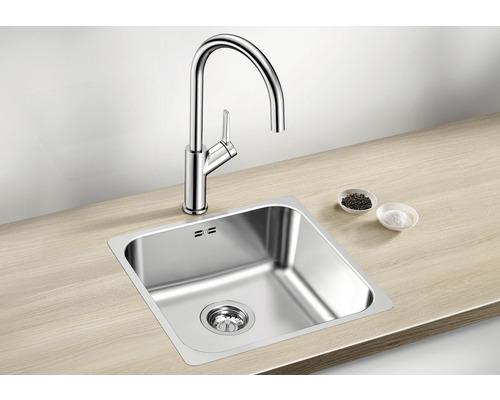 Évier en acier inoxydable avec robinet sur un plan de travail