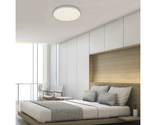 Schlafzimmer mit Doppelbett und runder Deckenleuchte