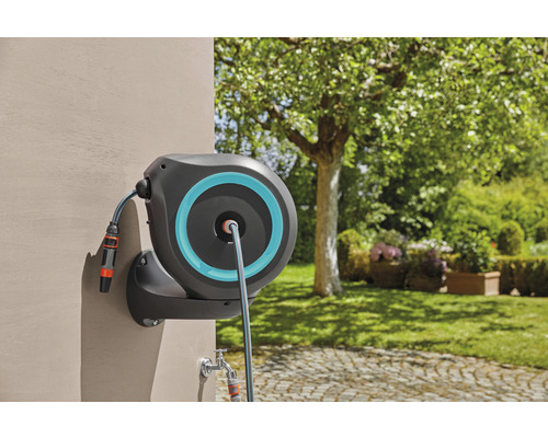 Dévidoir mural avec tuyau d''arrosage sur un mur de maison