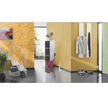 Couloir avec escalier, meuble à chaussures, porte-manteau et papier peint floral.