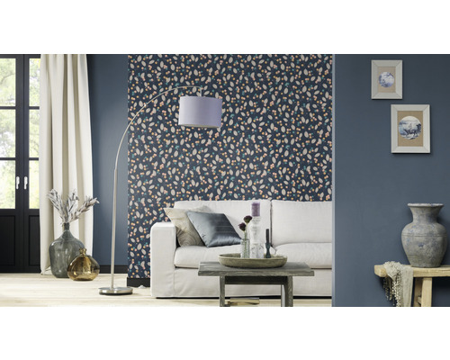 Wohnzimmer mit gemusterter Tapete, Sofa, Stehlampe und Dekoration